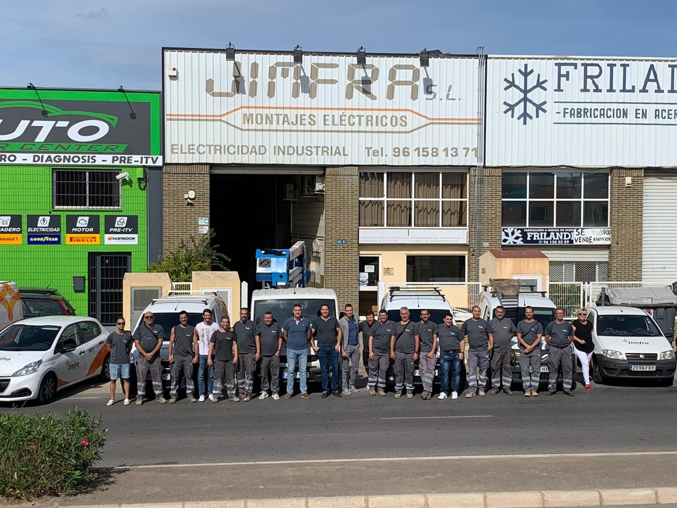 Equipo de JIMFRA junto a sus vehículos frente a las instalaciones de la empresa